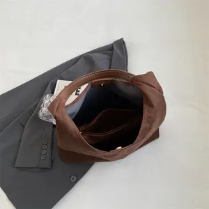 Vintage brown suede tote bag with large capacity shown on stylish blazer background