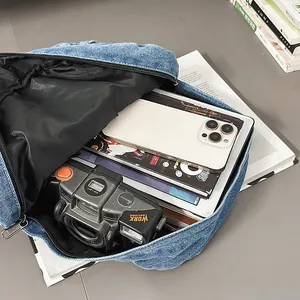 Vista interior de la espaciosa mochila de mezclilla azul con varios objetos personales