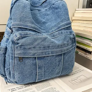 Primer plano de mochila de tela vaquera azul lavado con múltiples bolsillos y cremallera