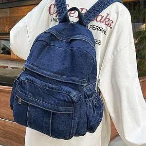 Mochila minimalista de mezclilla lavada azul oscuro con múltiples bolsillos y estilo retro