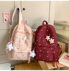 Detail of quilted backpack featuring delicate bow embroidery and star plush pendant