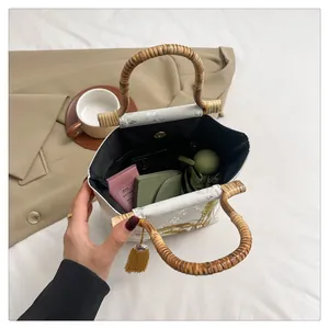New Chinese style embroidered crossbody bag with bamboo handle and yellow tassel on bed