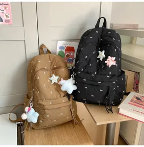 Detailed view of quilted backpacks with butterfly embroidery and star plush pendant
