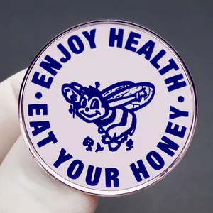 Runde Emaille-Brosche mit Honigbiene und Enjoy Health Eat Your Honey Text auf Silber