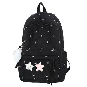 Black quilted backpack with white bow prints and plush star patches on white background
