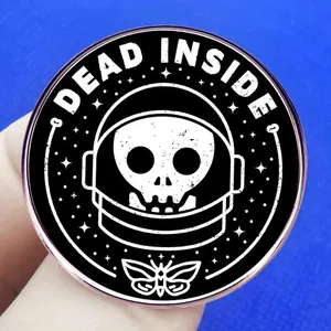 Dead Inside astronaut skull enamel pin with moth design on a blue textured background