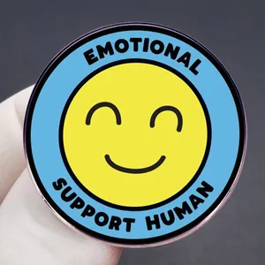 Emotional Support Human enamel pin with a yellow smiley face and light blue border