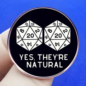 Black DND enamel pin featuring two D20 dice and 'Yes, They're Natural' text design