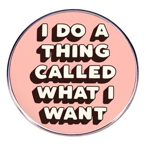 Pink metal brooch pin with 'I DO WHAT I WANT' motivational text in black and white
