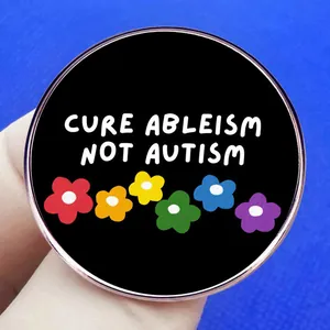 Cure Ableism Not Autism metal badge with rainbow flower pins and white typography