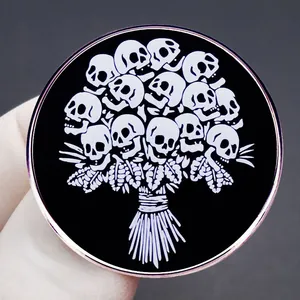 Broche ronde en émail style punk avec un bouquet de crânes au design gothique noir et blanc