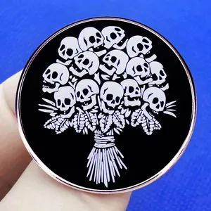Broche gothique en émail avec bouquet de crânes et bordure en métal or rose