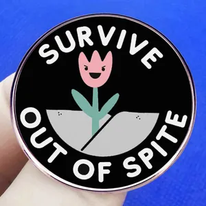 Round pink tulip enamel pin with SURVIVE OUT OF SPITE text on black metal base