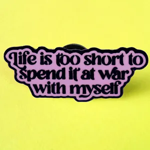 Pin's inspirant Life Is Too Short en émail violet sur un fond jaune vif éclatant