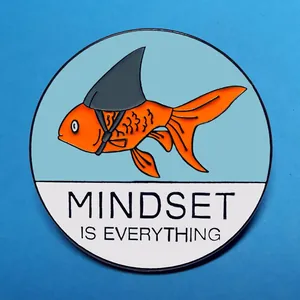 Goldfisch-Emaille-Pin mit Haiflosse und Mindset Is Everything-Text auf blauem Grund