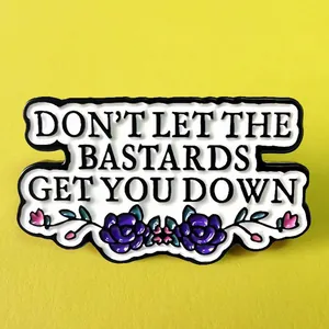 Enamel brooch with 'Don't Let The Bastards Get You Down' quote and floral accents