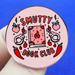 Pink Smutty Book Club round enamel pin featuring flame book and handcuffs design