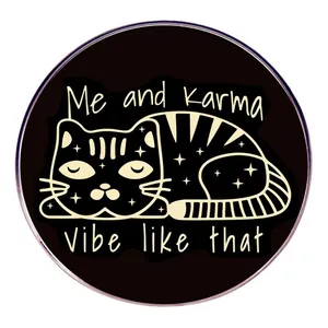 Détail de l'insigne métallique rond avec un chat étoilé dessiné à la main et un slogan