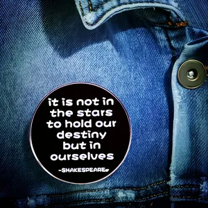 Round Shakespeare brooch with black finish pinned on blue denim jacket pocket
