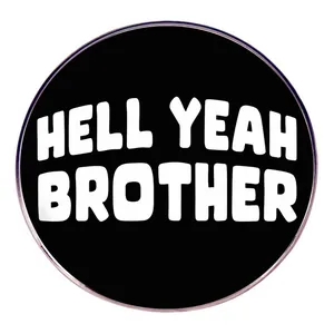 Vue détaillée du badge rond en métal avec le texte gras blanc HELL YEAH BROTHER
