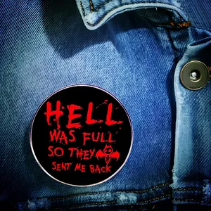 Détail d'un pin's gothique sur une veste en jean avec texte rouge Hell Was Full et chauve-souris