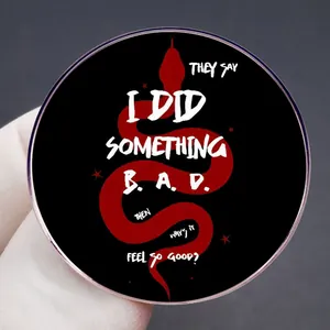 Black round enamel badge with red snake motif and white artistic lettering details