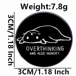 Round black enamel pin with funny cat drawing and Overthinking and Also Hungry text