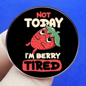 Cartoon strawberry pin with 'Not Today I'm Berry Tired' slogan on black background