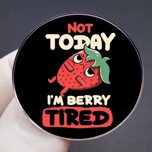 Cartoon strawberry pin badge with Not Today I am Berry Tired text on black metal