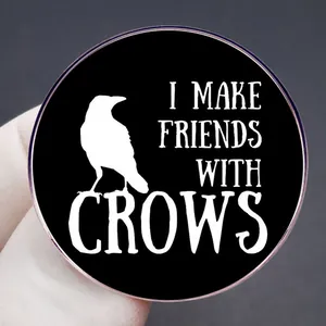 Broche corbeau ronde avec texte I MAKE FRIENDS WITH CROWS et bord doré rose