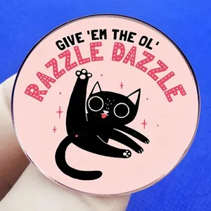Broche chat noir cartoon rose avec inscription 'RAZZLE DAZZLE' sur badge rond