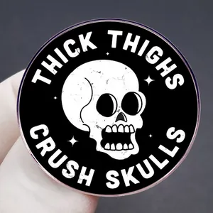 Thick Thighs Crush Skulls enamel pin badge with a white skull and gothic lettering