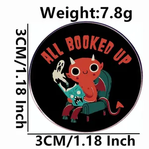 Pin's All Booked Up démon, badge en métal rond avec petit diable lisant sur un canapé