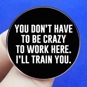 Funny black round pin with You Don't Have To Be Crazy To Work Here white text