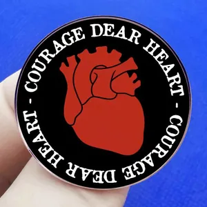 Enamel brooch with anatomical red heart and Courage Dear Heart slogan on black metal