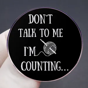 Enamel pin featuring 'Don't Talk To Me I'm Counting' quote with knitting yarn illustration