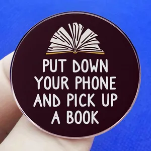 Round purple acrylic brooch with Put Down Your Phone and Pick Up a Book slogan