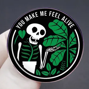 Black enamel pin with skull and plant design featuring You Make Me Feel Alive quote