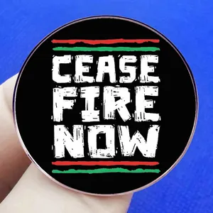 Ceasefire Now metal badge pin with red and green stripes on a black round background