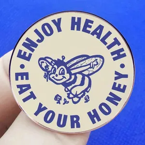 Retro Eat Your Honey bee pin brooch in acrylic style held against a blue background