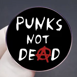 Punk Not Dead rock pin badge with anarchy symbol held by hand on dark background