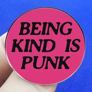 Pink enamel pin featuring 'BEING KIND IS PUNK' text with a polished metal edge