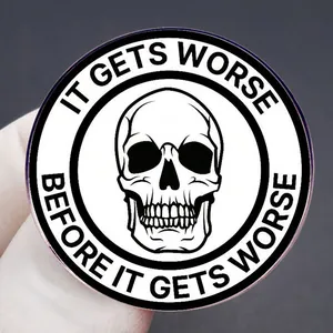 Enamel skull brooch with It Gets Worse quote on round black and white pin badge