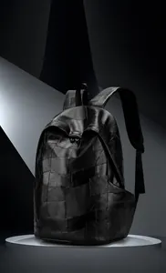 Detail of minimalist black PU leather backpack with irregular patchwork stitching design