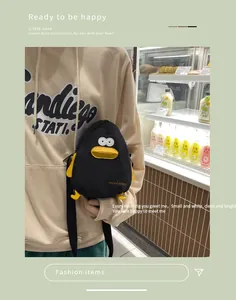 Close-up of black canvas penguin crossbody bag with cute 3D duck beak detail and strap