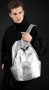 Detail of silver geometric patchwork backpack with metallic finish and black straps
