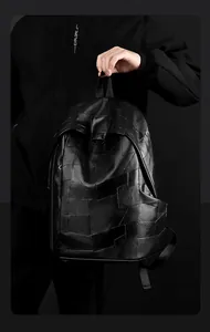 Detail of minimalist black PU leather backpack with geometric patchwork stitching