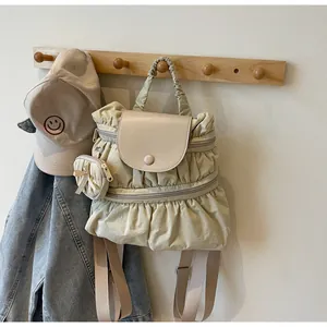 Detail van beige geplooide nylon rugzak met leren klep en bijpassende strik portemonnee