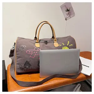 Gros plan d'un sac de voyage en toile à graffiti avec poignées en cuir sur un banc