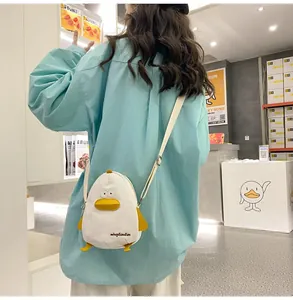 Rear view of a model wearing the cute white canvas duck-shaped crossbody phone bag